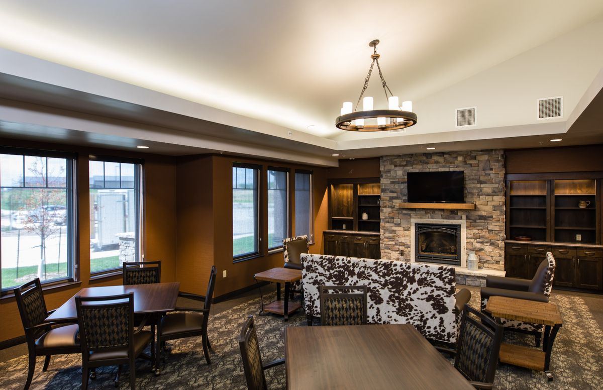 A modern living room featuring a cozy fireplace, comfortable seating, and a stylish lighting fixture.