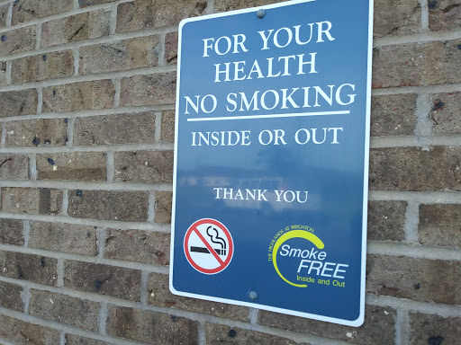 A sign indicating a no smoking policy for the health of all individuals, applicable both inside and outside.