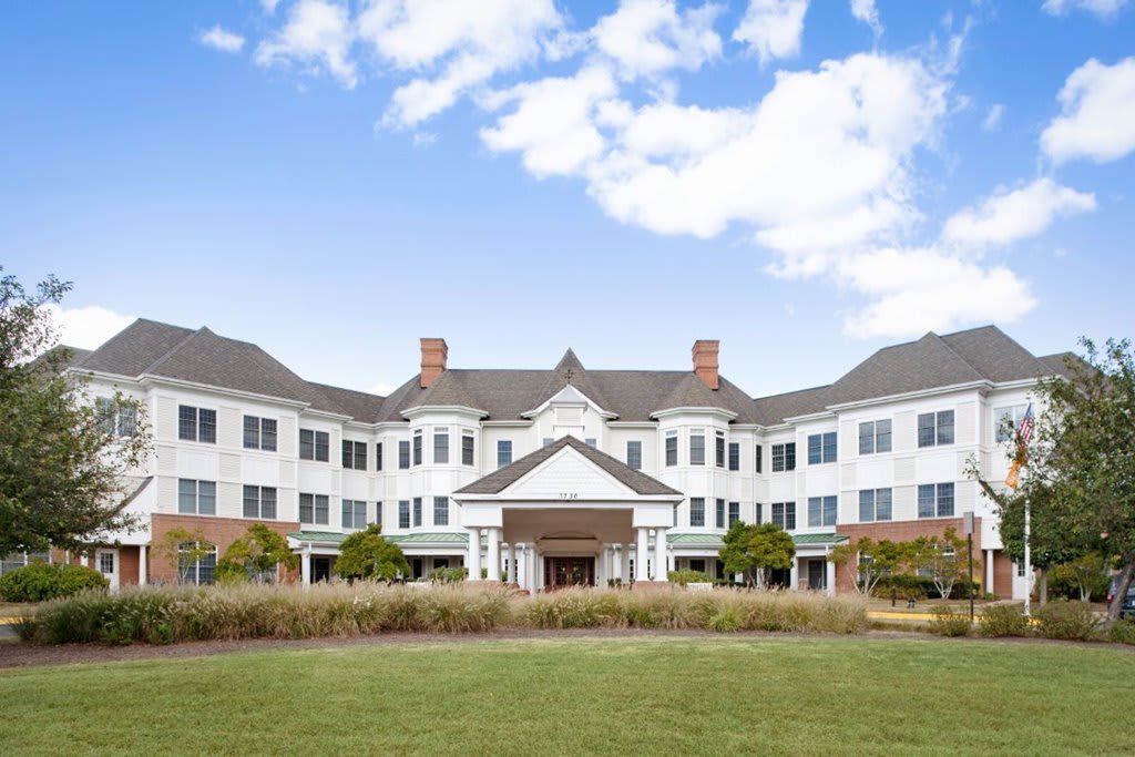 A large, symmetrical building with a classic architectural design under a partly cloudy sky.