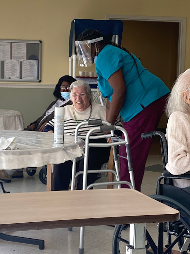 Residents enjoying time with caregivers at a nursing facility.