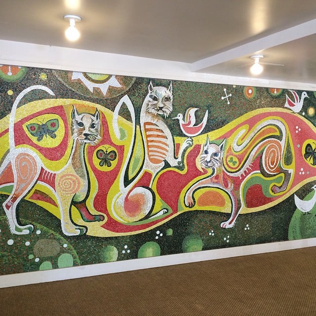 A vibrant mural featuring abstract, colorful cats on a wall.