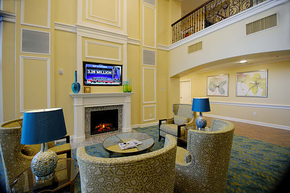 A cozy lobby with a fireplace, seating area, and television.