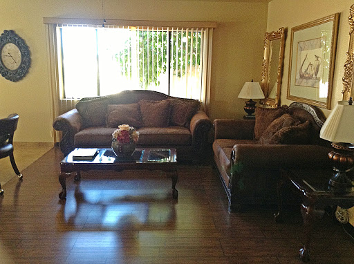 A cozy living room featuring comfortable couches and a coffee table, illuminated by natural light from the window.