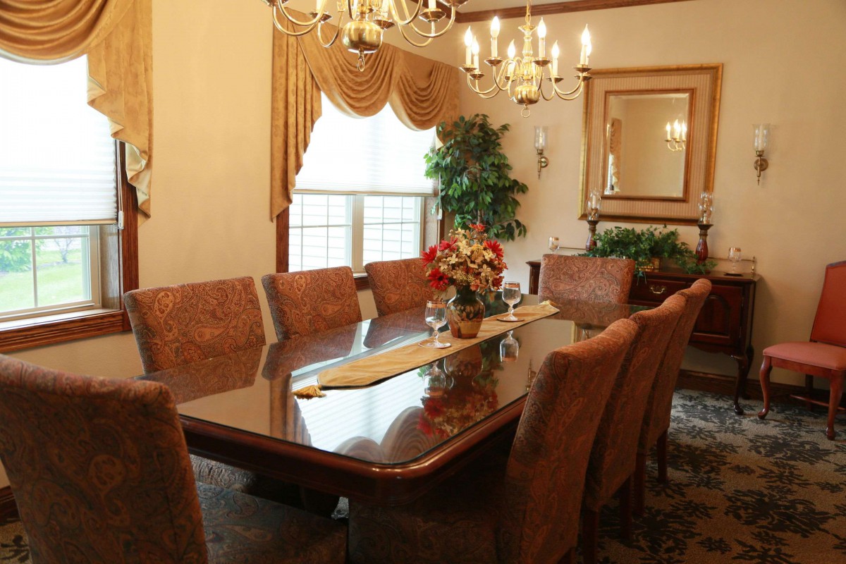 Elegant dining room with a large table, chandelier, and decorative elements.