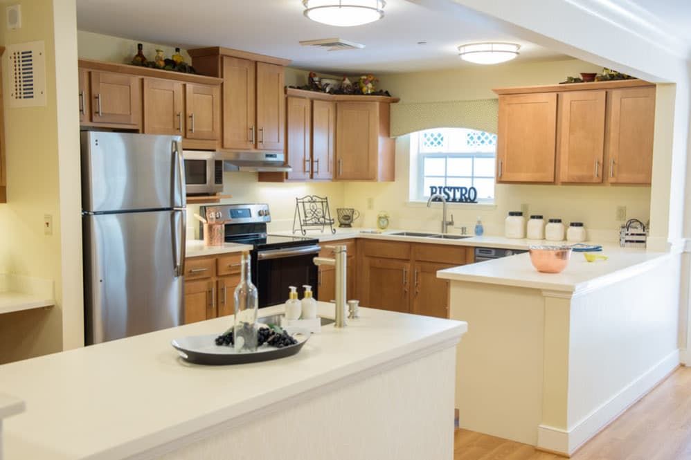 A modern kitchen with wooden cabinets, stainless steel appliances, and a spacious island.