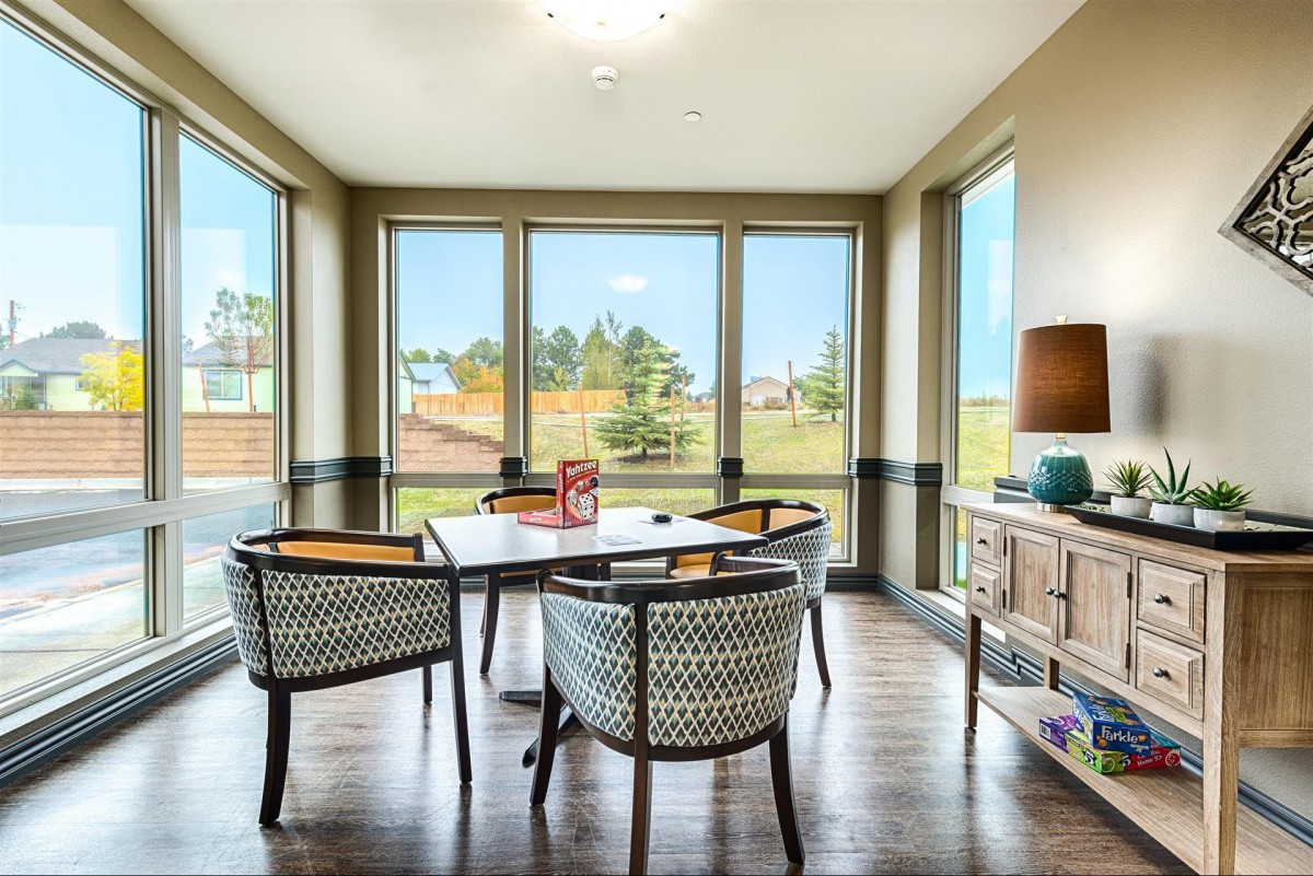 A modern dining room with large windows allowing natural light to illuminate the space.