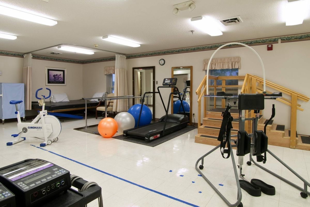 A rehabilitation gym equipped with treadmills and exercise balls for physical therapy.