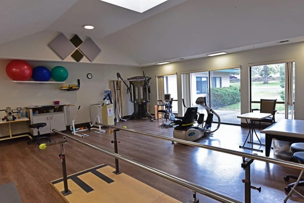 A well-equipped gym with various exercise machines and rehabilitation equipment.