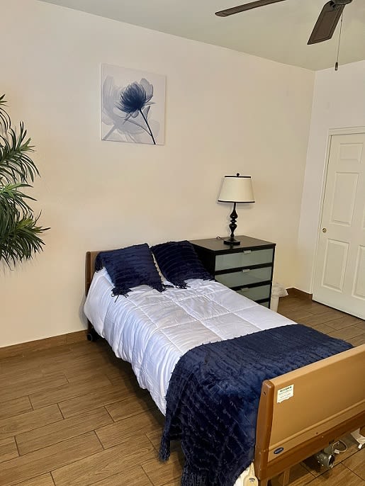 A cozy bedroom with a single bed, blue bedding, and minimalist decor.