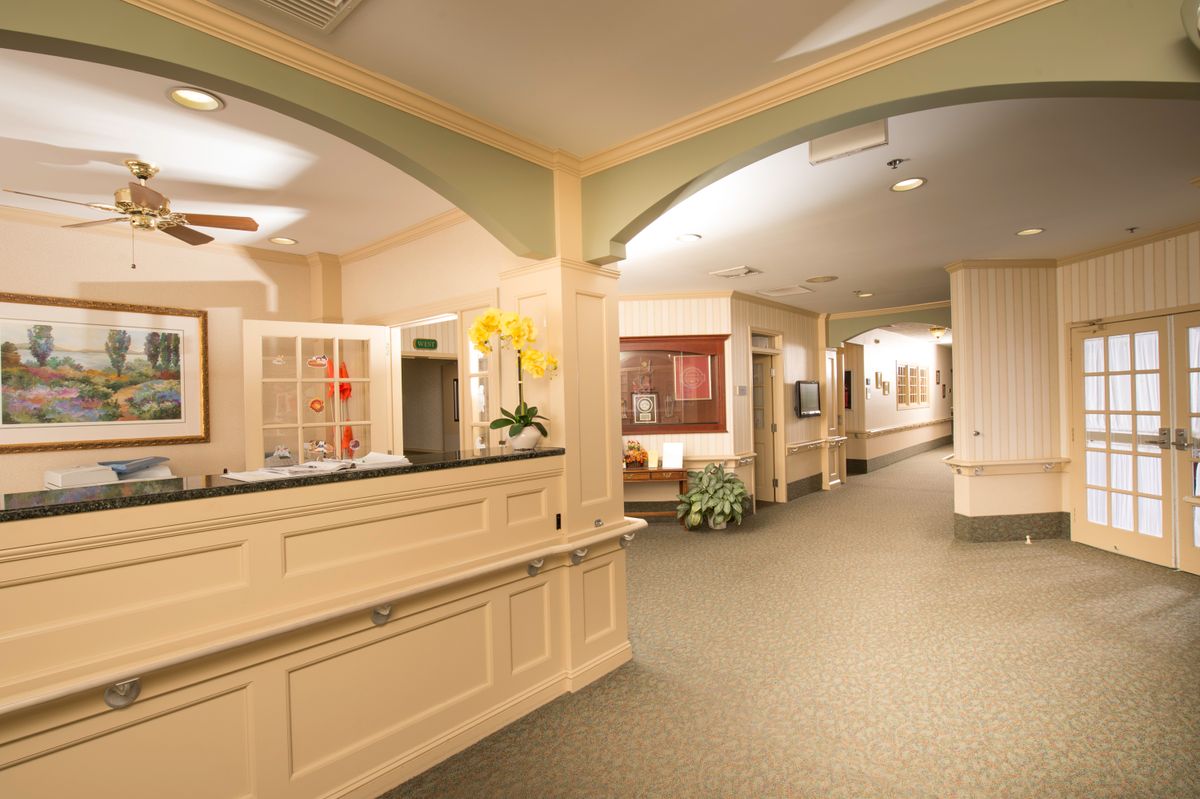 A modern interior lobby with a reception desk and hallway.