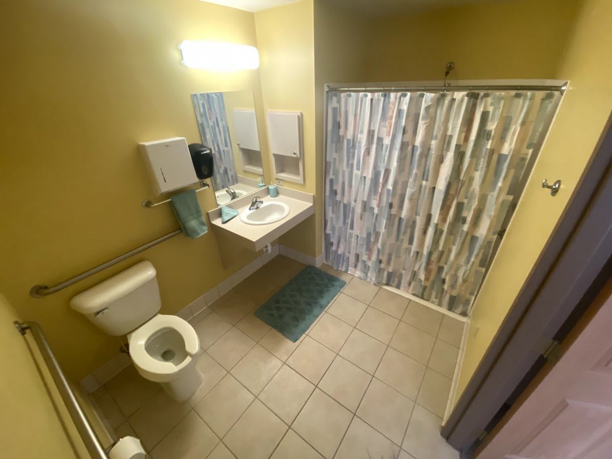 A clean, modern bathroom with a shower, toilet, and sink.