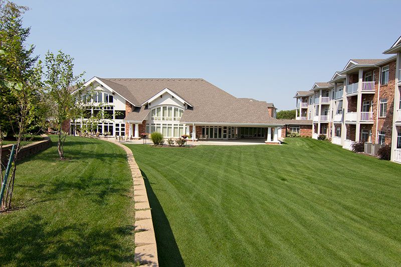 A large luxury home with a spacious green lawn and modern architectural design.