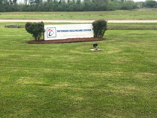 Signage for a healthcare center surrounded by a well-maintained lawn.