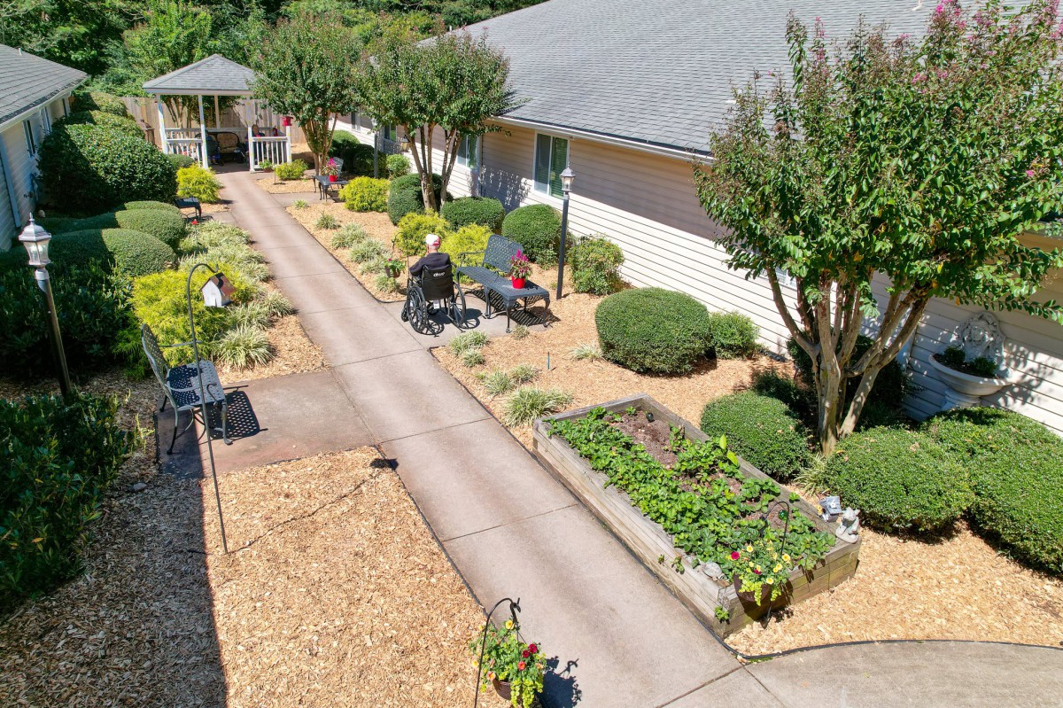 A beautifully landscaped garden with a pathway, vegetable garden, and outdoor seating area.