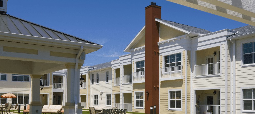 A modern apartment building with balconies and large windows on a sunny day.