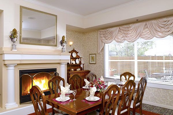 An elegant dining room with a fireplace and beautifully set table.