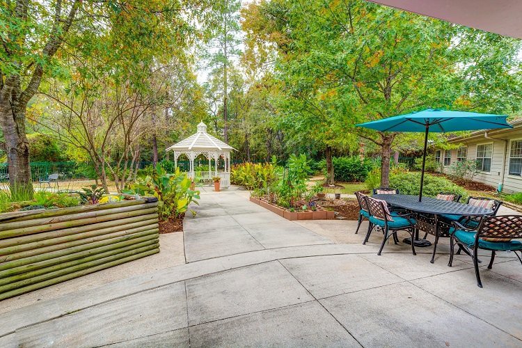 A tranquil garden with a gazebo and furnished patio area.