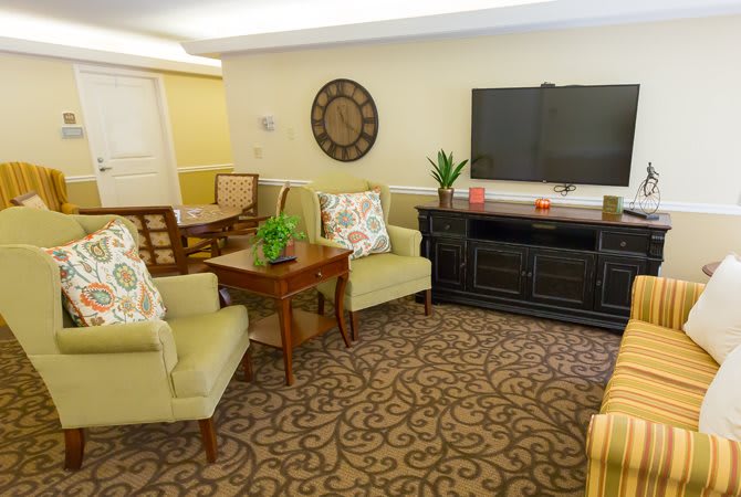 A cozy living room with comfortable seating, a television, and decorative elements.