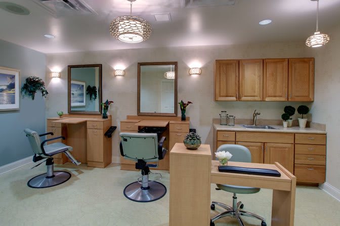A modern salon interior featuring chairs, mirrors, and ample lighting.