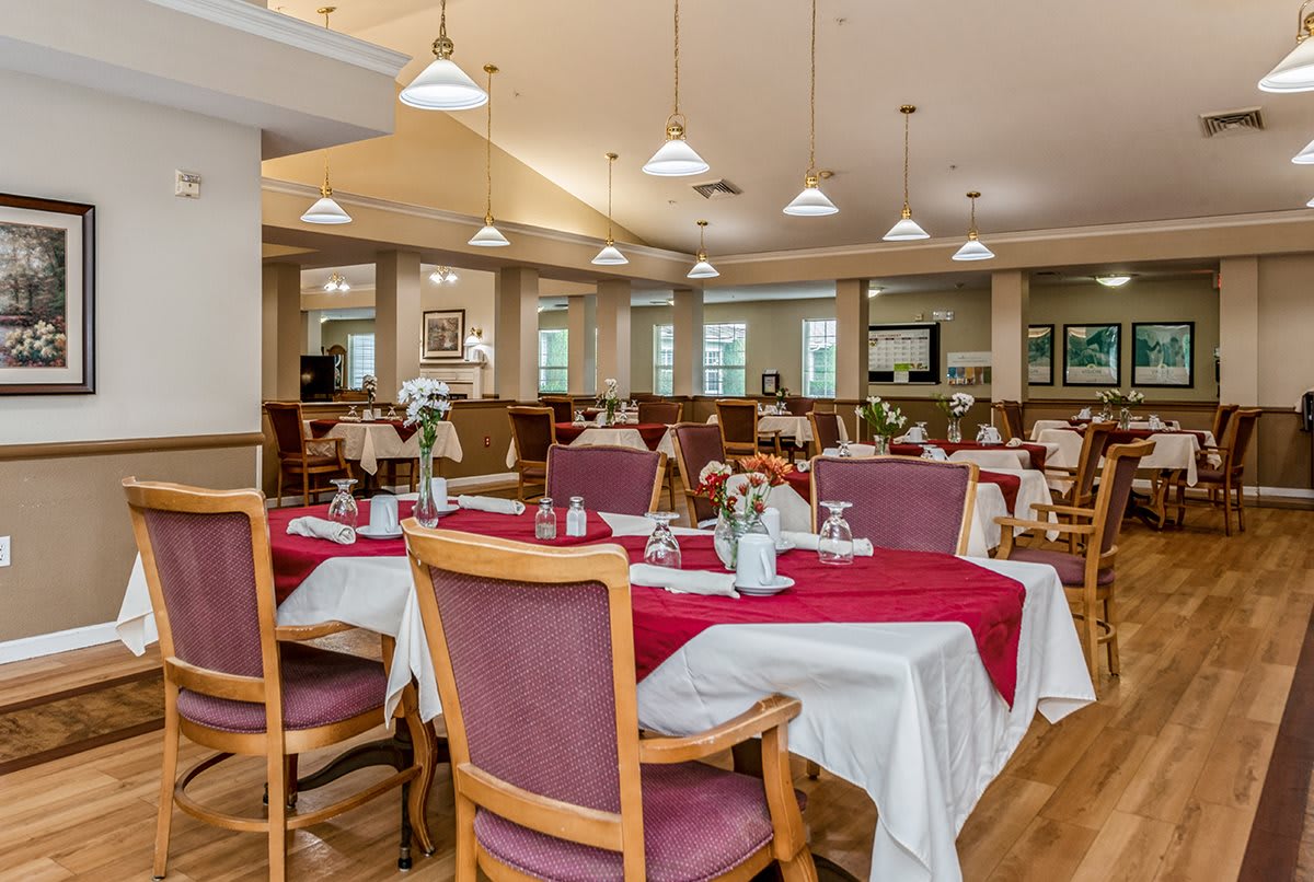A well-lit restaurant dining area with neatly arranged tables and chairs, featuring elegant decor.