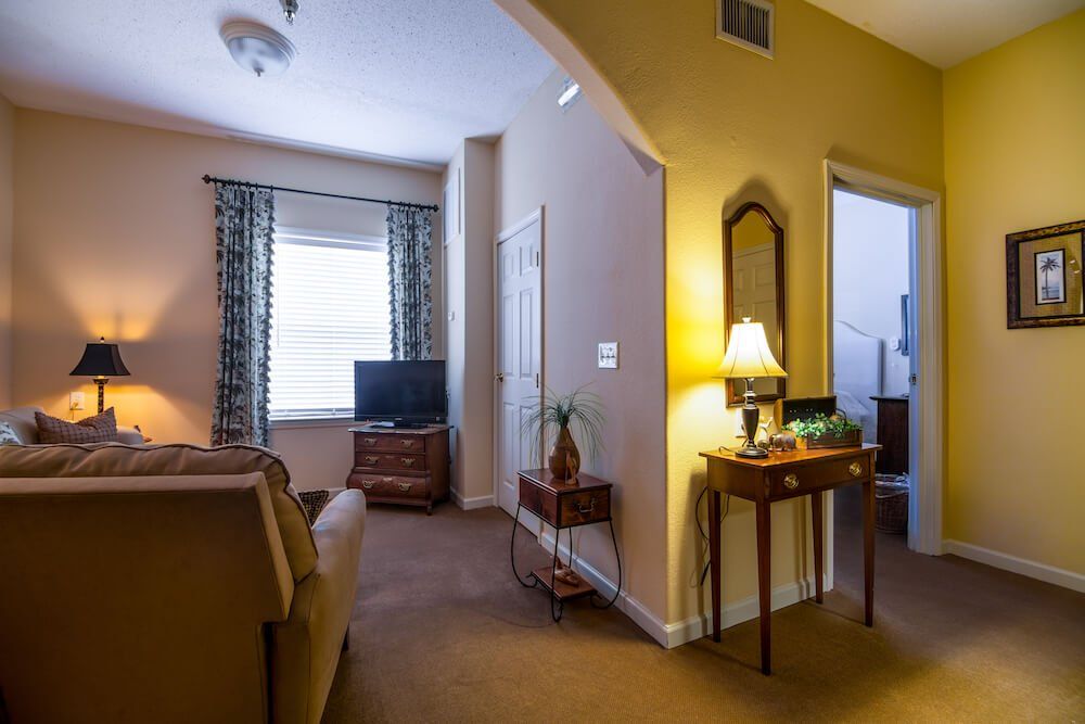Cozy living room with a TV, lamp, and comfortable seating.