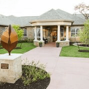 A welcoming building entrance with a landscaped path and a modern sculpture.