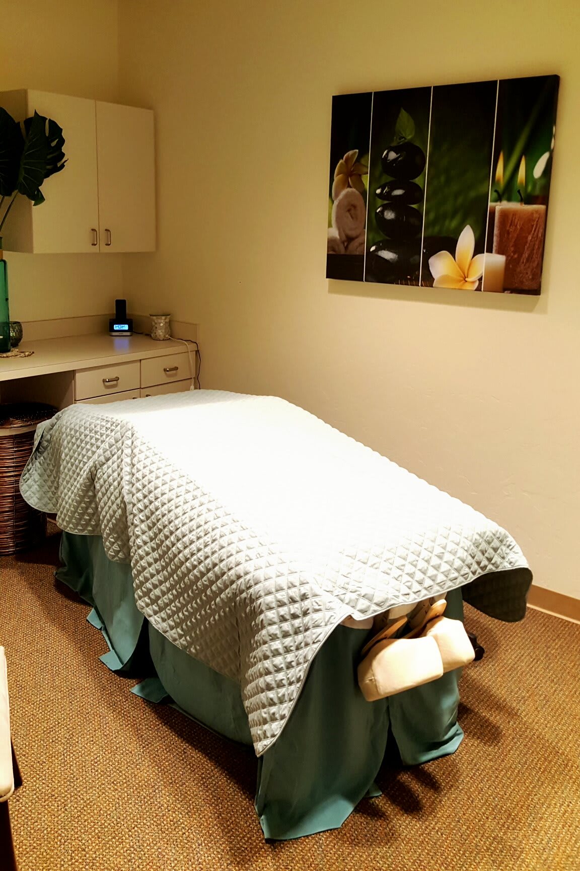 A tranquil massage room with a neatly made bed, ideal for relaxation and therapy.