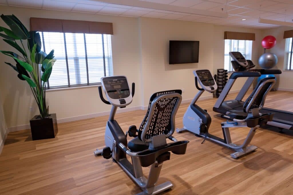 A well-equipped gym with stationary bikes and a wall-mounted TV.