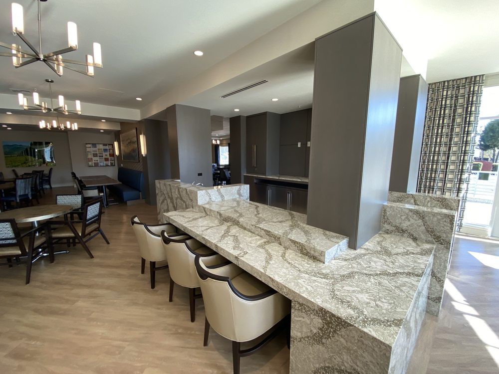 A modern kitchen with a sleek countertop and seating area.