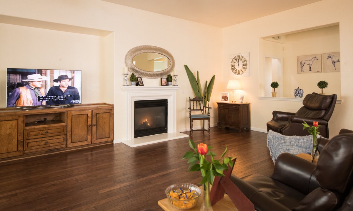 A cozy living room featuring a warm fireplace, elegant decor, and comfortable seating.