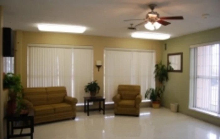 A cozy living room with sofas, chairs, and a ceiling fan.