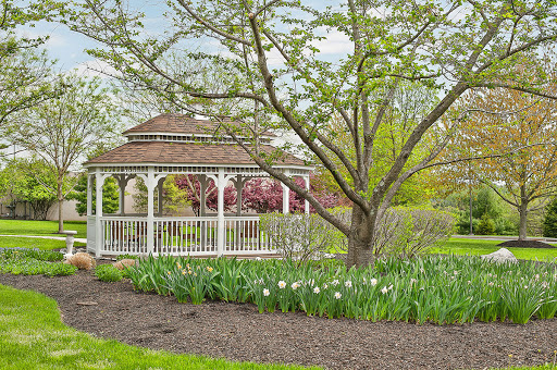 A serene garden scene featuring a charming gazebo surrounded by lush greenery and blooming flowers.