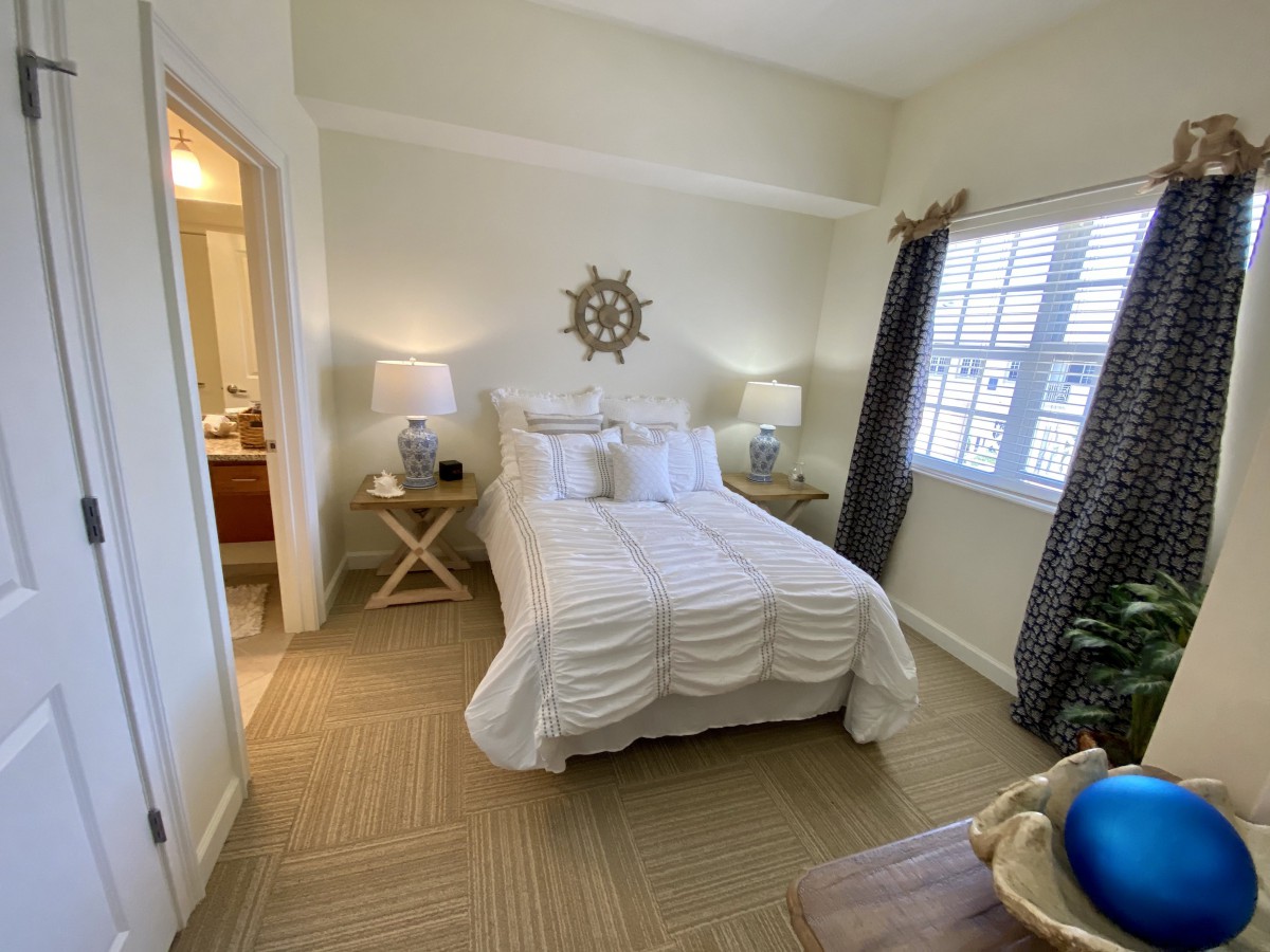 A cozy bedroom with a neatly made bed, two nightstands, and decorative elements.