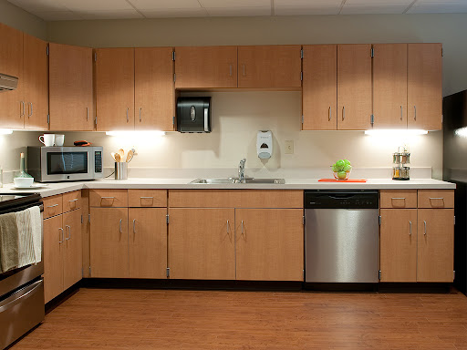 A modern kitchen featuring wooden cabinets and essential appliances.