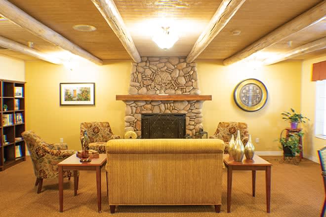 A cozy living room featuring a stone fireplace, comfortable seating, and warm lighting.