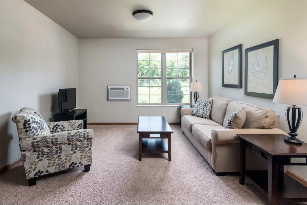 A cozy living room with a sofa, coffee table, and a TV.