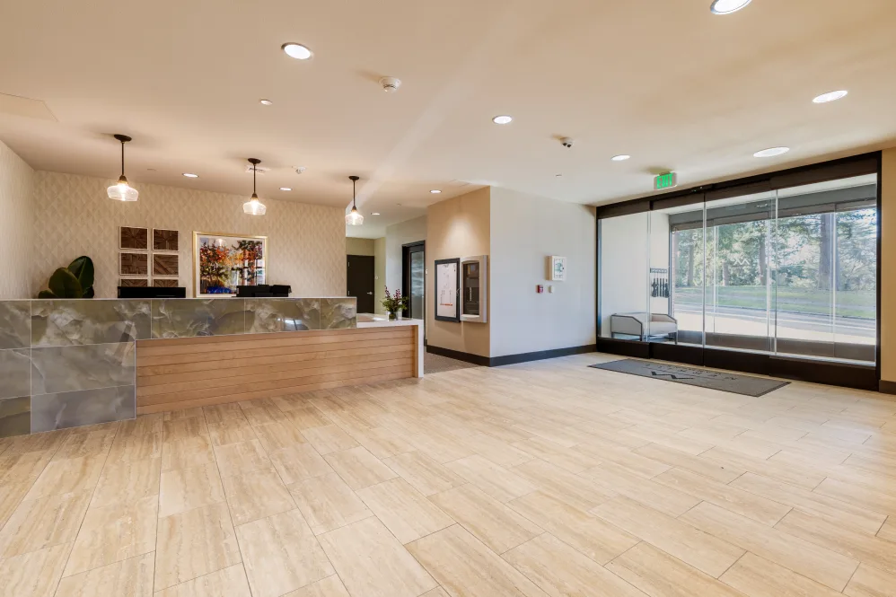 Modern office lobby with a reception desk and seating area.