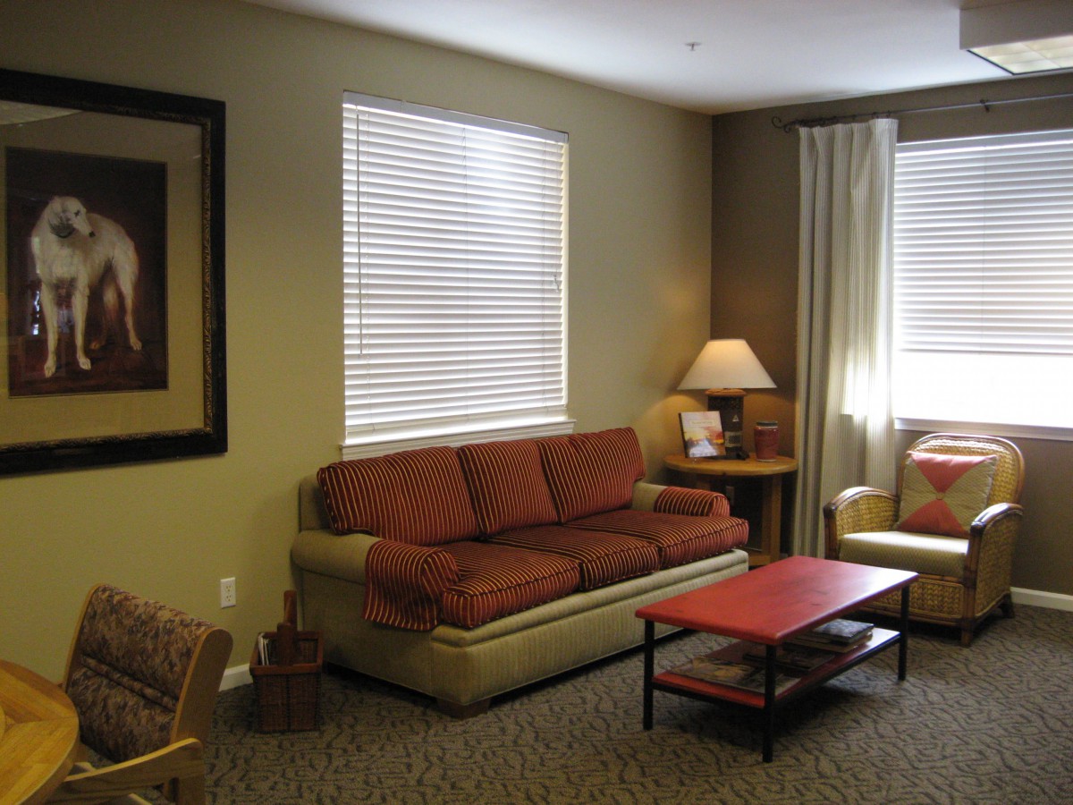 A cozy living room with a sofa, coffee table, and lamp.