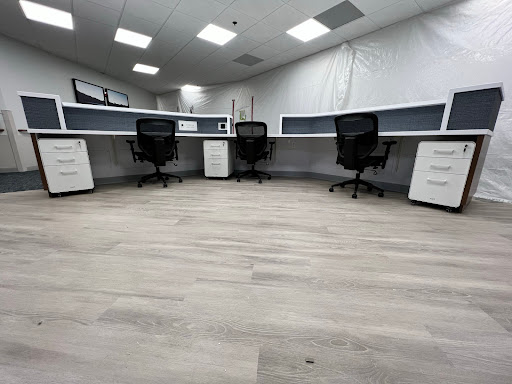 A modern office space featuring minimalist desks and ergonomic chairs.