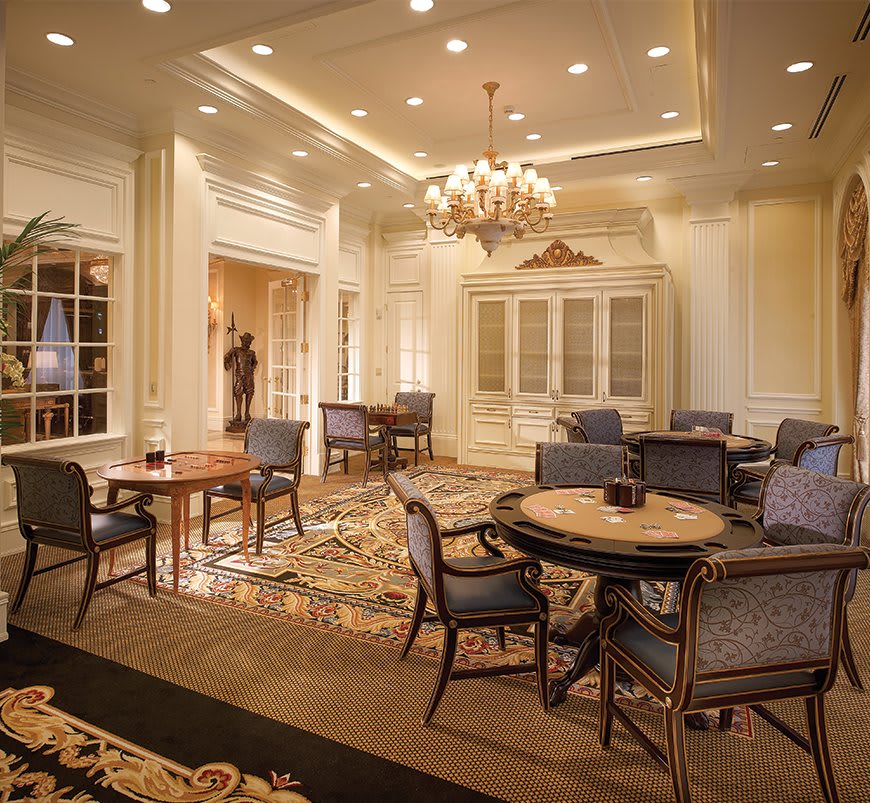 A luxurious lounge area featuring elegant furniture and a grand chandelier.