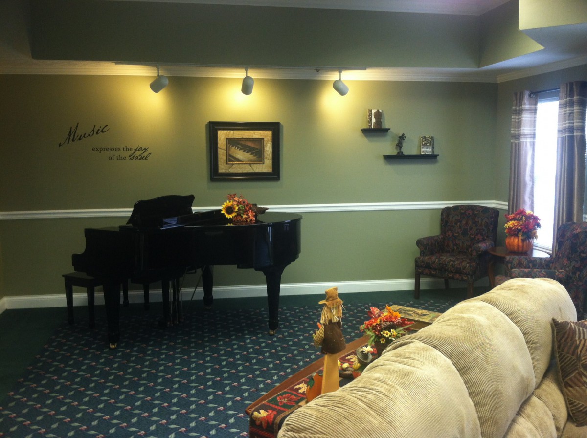 A cozy living room featuring a grand piano and elegant decor.