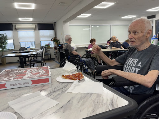 Residents enjoying a meal together in a care facility.