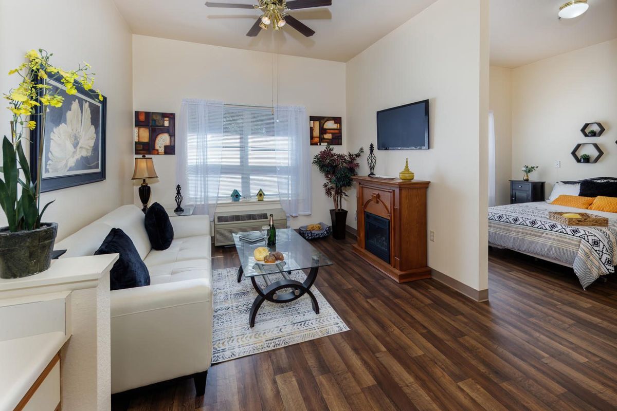 A modern living room with a white sofa, wooden flooring, and a cozy atmosphere.