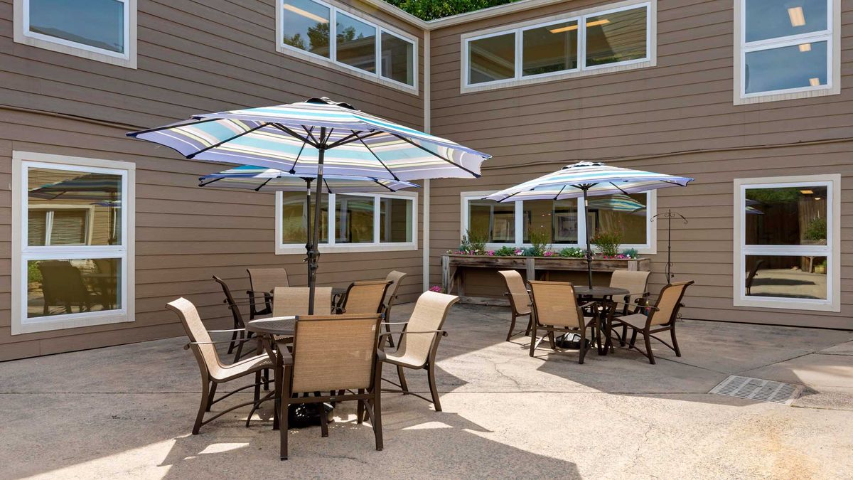 An outdoor patio area with tables, chairs, and umbrellas.