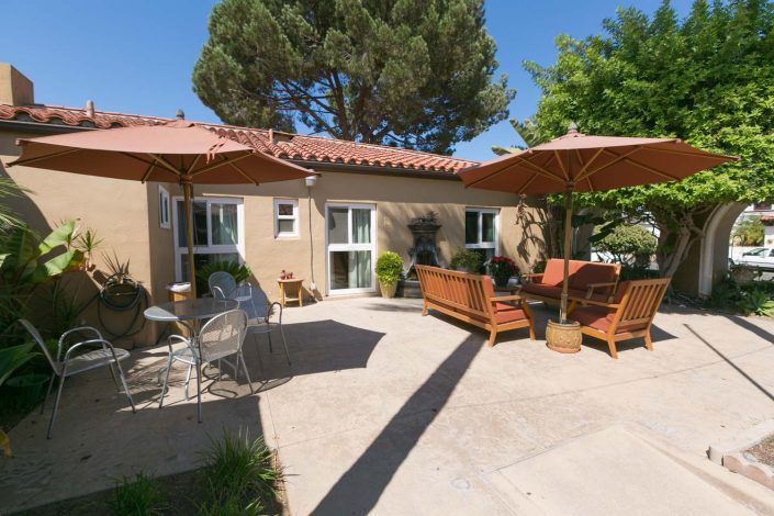 A sunny patio with comfortable outdoor seating and umbrellas.