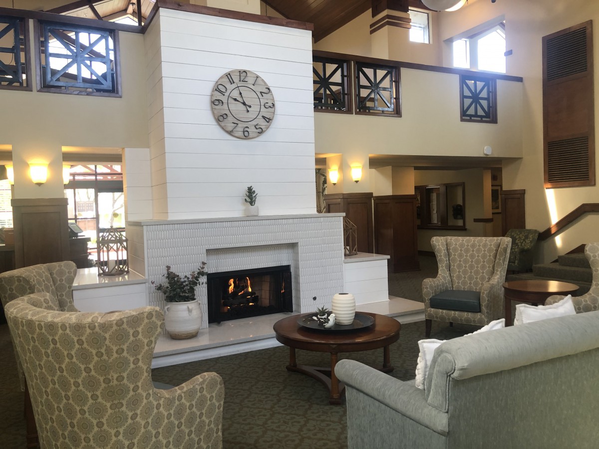A cozy living room with a modern design, featuring a central fireplace and comfortable seating.