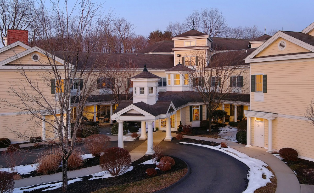 A luxurious mansion surrounded by trees in winter.