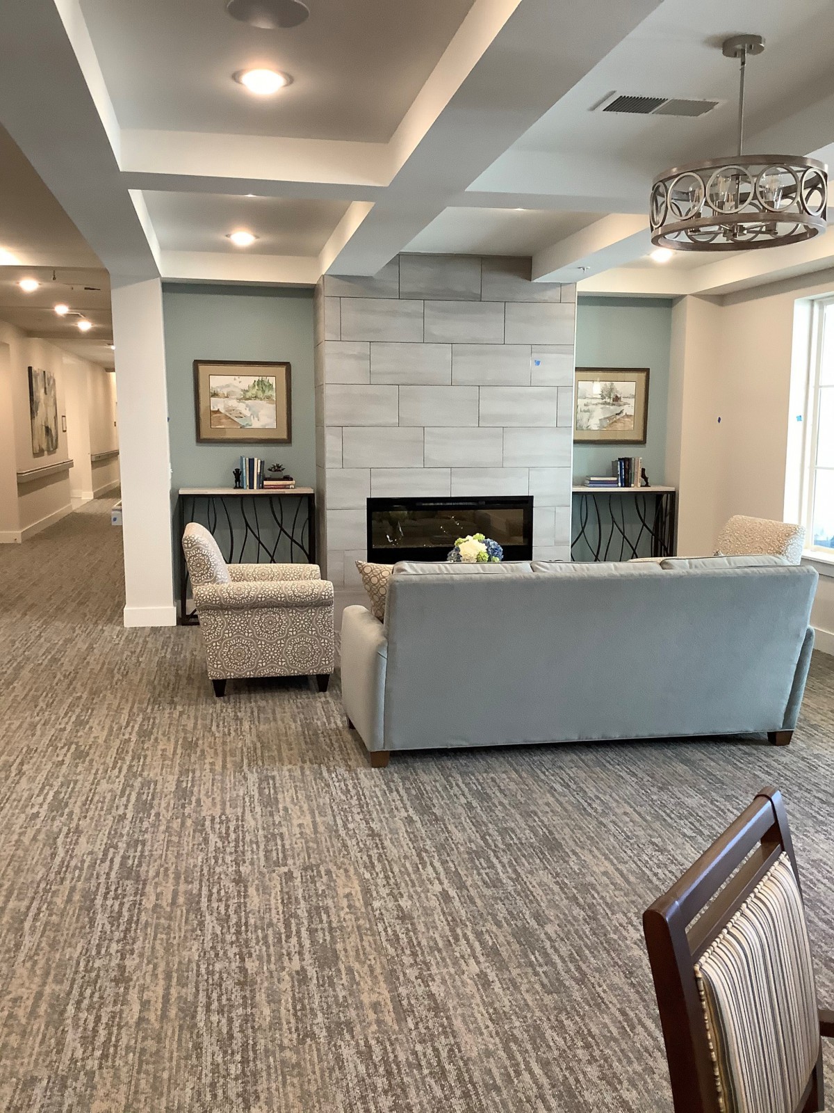 A modern living room with a cozy seating area around a fireplace.