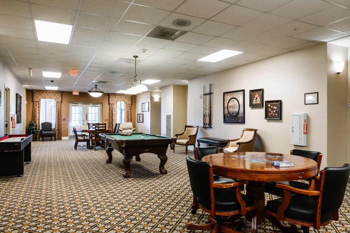A spacious game room featuring a pool table and comfortable seating.