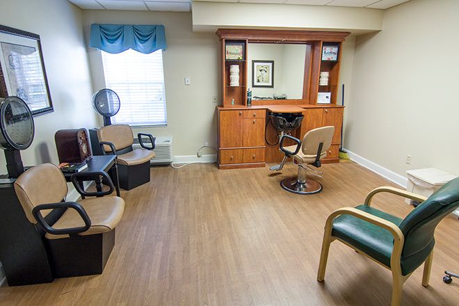 A quiet salon with a waiting area, equipped with chairs and a hair drying station.